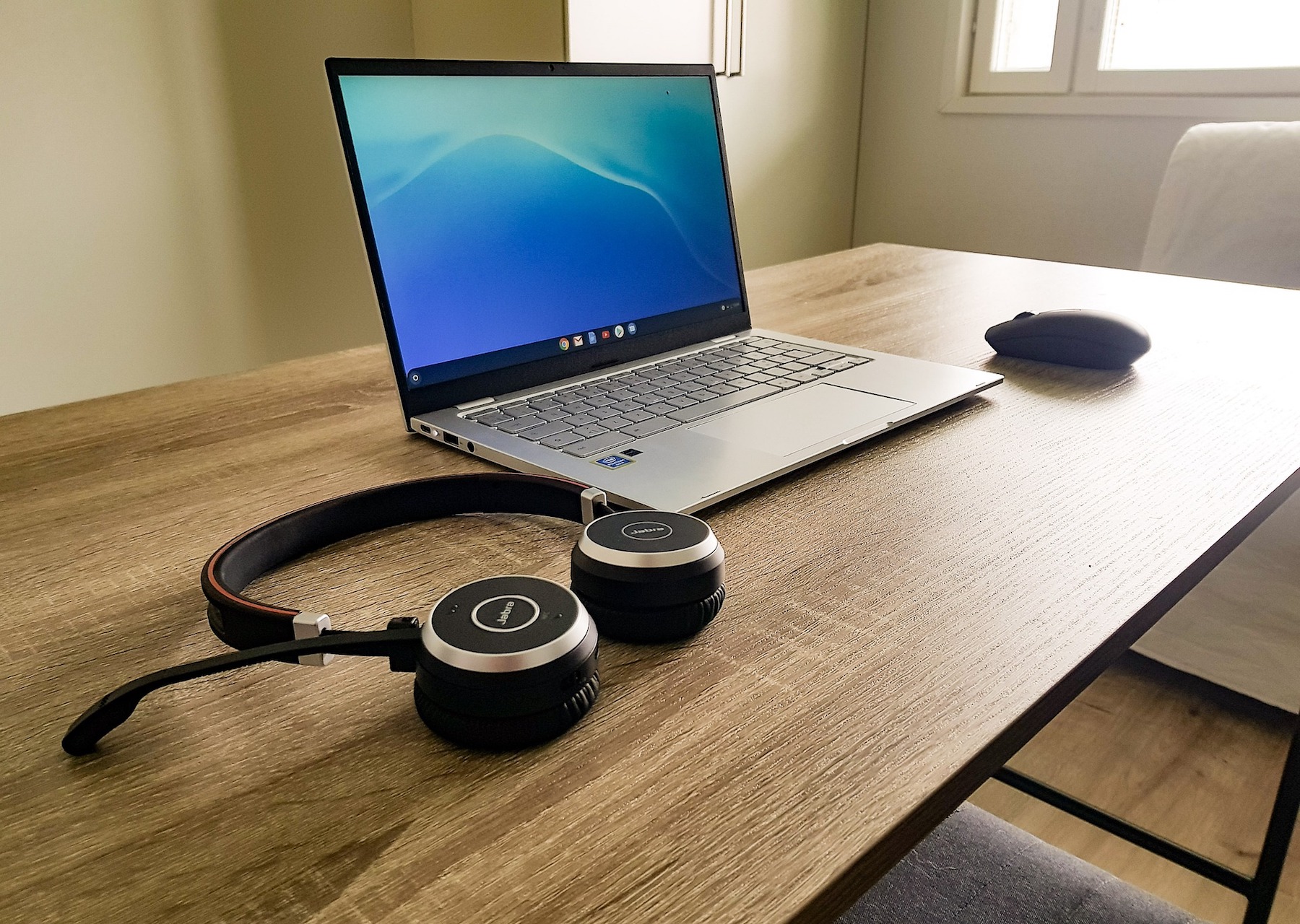 Laptop, myszka i słuchawki na biurku
